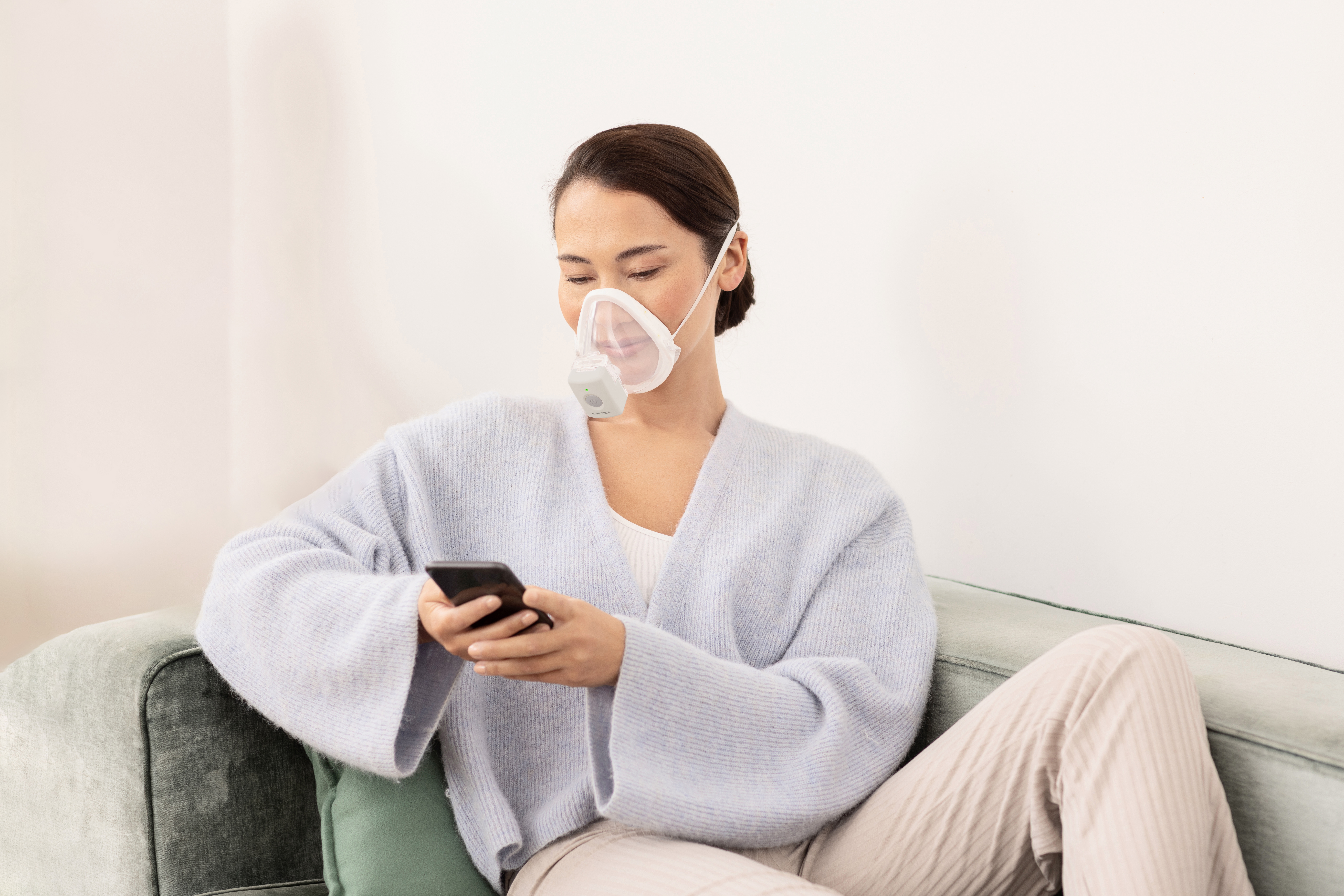 Frau nutzt den medisana IN 705 Inhalator mit Maske bequem auf dem Sofa – effektive Inhalationstherapie bei Atemwegserkrankungen